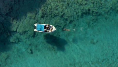 paxos, grecia - turistas nadando en la costa de la isla en el mar mediterráneo