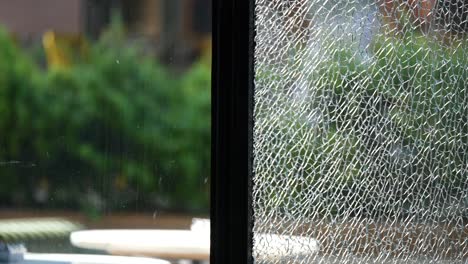 shattered window glass with greenery view