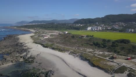 Panoramic-view-of-Portuguese-amazing-shore,-showing-the-beach-with-calm-waves-and-the-village-of-Caminha,-Portugal