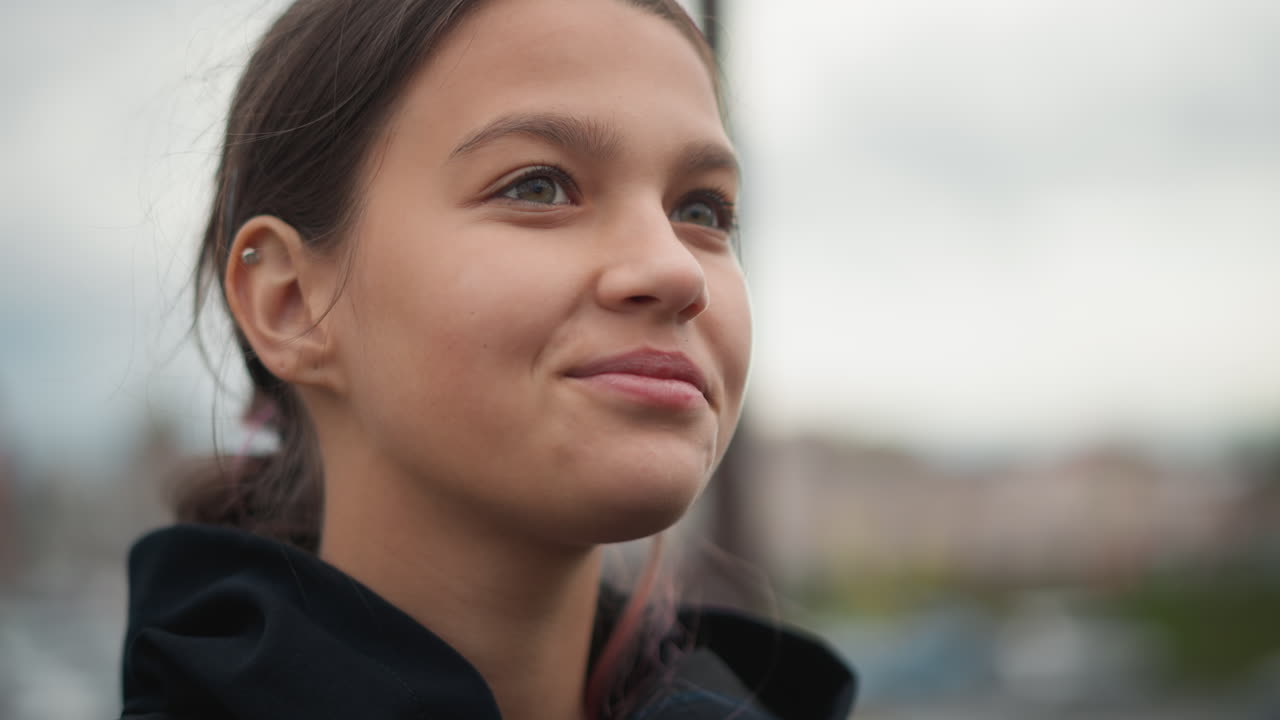 Profilo di giovane donna che sorride dopo la pioggia su un tetto tranquillo, sguardo dolce verso l'alto con delicate goccioline nei capelli, espressione calma e paesaggio urbano pacifico sullo sfondo, umore speranzoso e riflessivo.