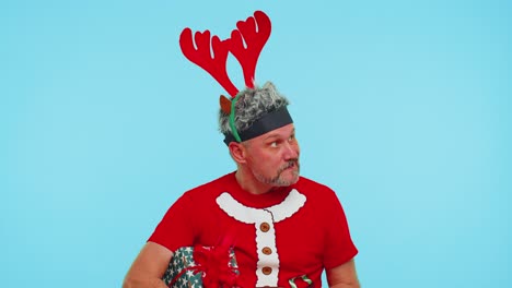 upset angry man in christmas deer antlers raising hands in indignant expression quarreling conflict