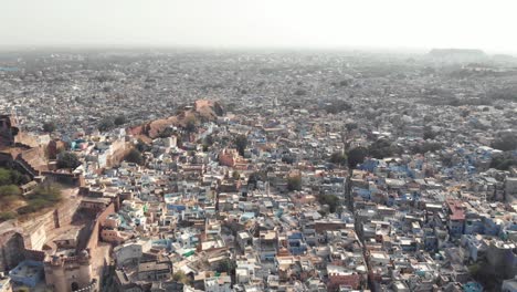 jodhpur blue city landscape composed by small buildings surrounding mehrangarh fort in rajasthan, india - aerial wide slide shot