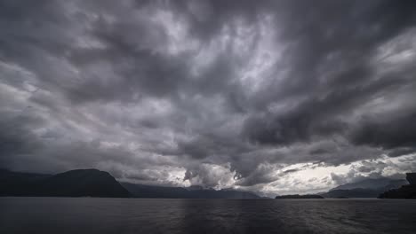 dark menacing stormy clouds move fast above the fjord