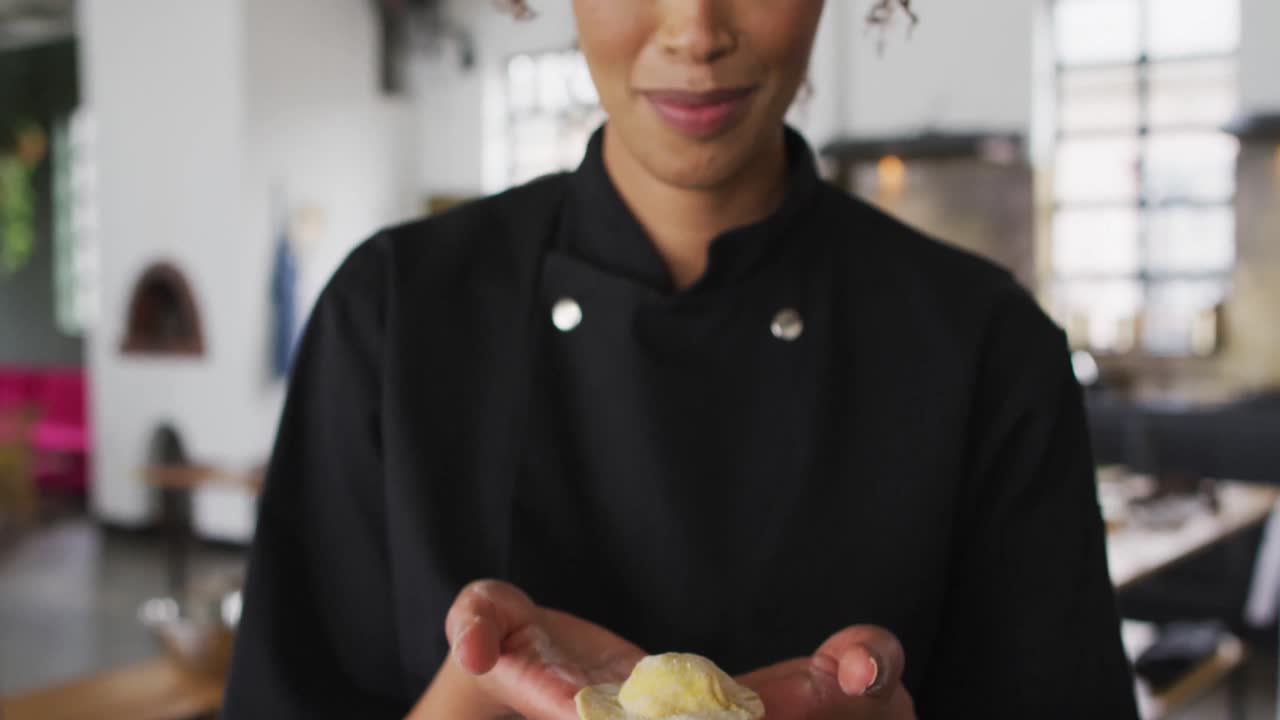cocinera de raza mixta mostrando una hamburguesa a la cámara