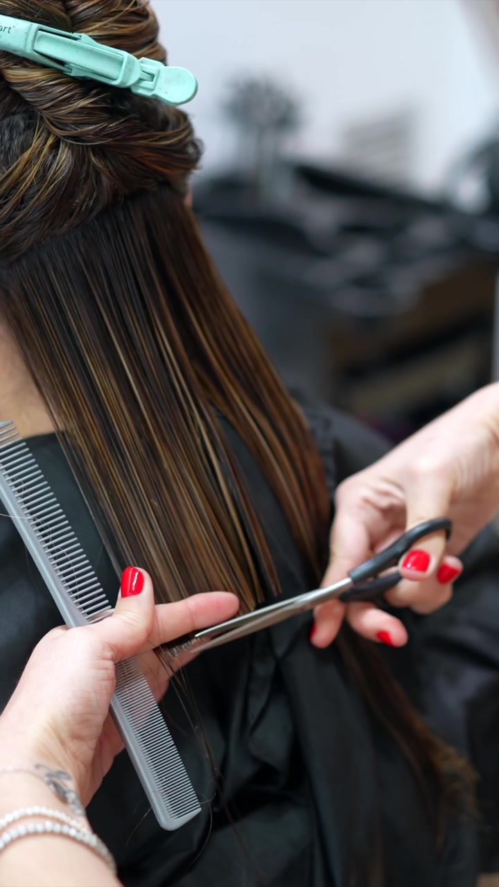 Parrucchiere professionista che taglia i capelli a un cliente in salone