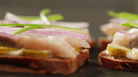 close-up of smoked fish sandwiches with pickles and onions