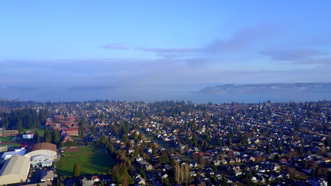 vista panorámica de exuberantes árboles verdes y hermosas casas en el barrio de tacoma cerca de la bahía de inicio en washington, ee.uu. en un día soleado - toma aérea