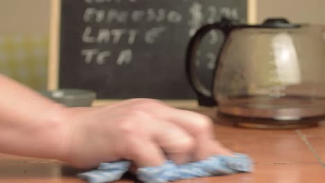 Hands-cleaning-down-cafe-table-close-up-shot