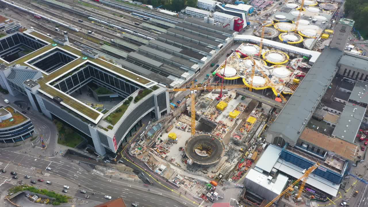 antena de enormes vías férreas y obra de construcción de la estación principal de tren stuttgart s21 con grúas, automóviles y trabajadores de la construcción en stuttgart, alemania