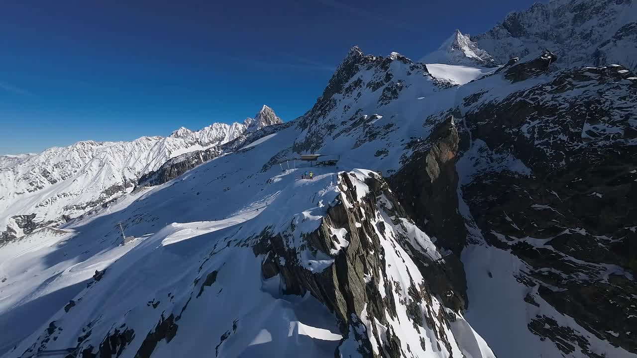 vista aérea sobre una cresta de montaña nevada en un día soleado con un cielo azul claro, cerca de la estación de esquí de la región de chamonix