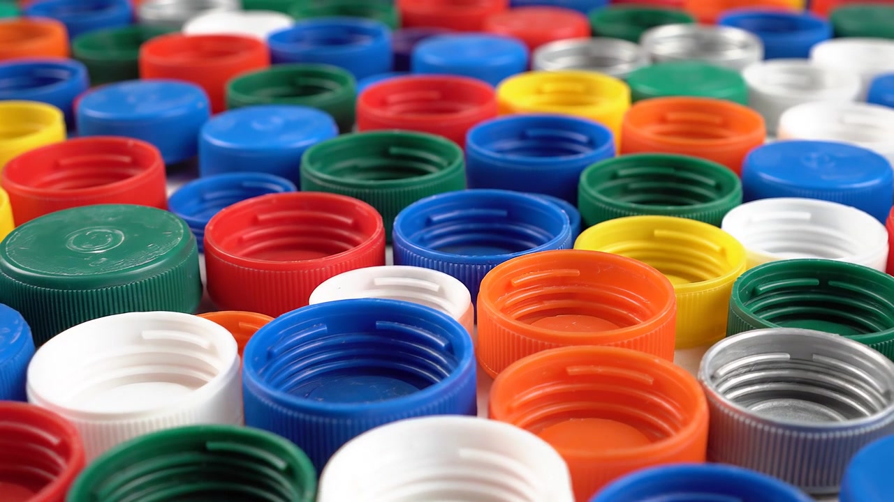 Sfondo ravvicinato di numerosi tappi di bottiglia di plastica colorati