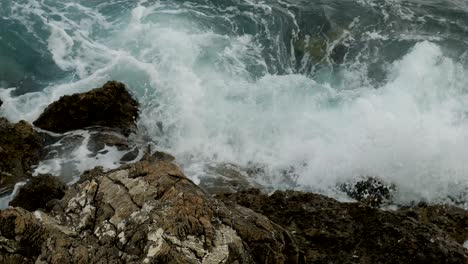 waves beating on the rocks on the beach in montenegro