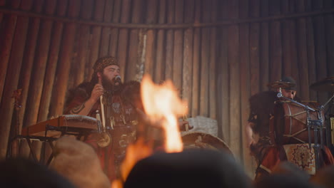 plump man sings while friend plays drums in altai house