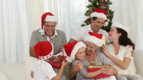 family holding christmas presents at home