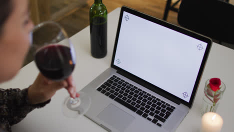 Caucasian-woman-having-a-romantic-dinner-on-video-chat-using-laptop-with-copy-space