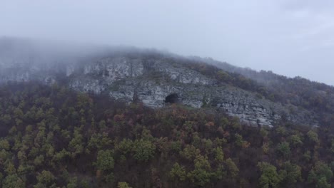 Retreating-drone-of-Kozarnika-Cave-and-showing-the-rest-of-the-Balkan-Mountain-range,-located-in-Dimovo-Municpality-in-Bulgaria