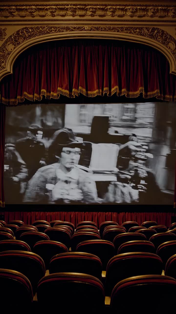 The video captures an empty vintage theater with red curtains and a large screen displaying '10:11'