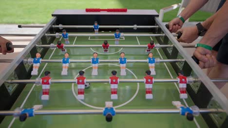 foosball competition between young men in the hall insert shot, close up shot