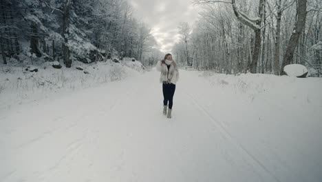 woman walking on snow covered trail in winter park at orford, quebec, canada