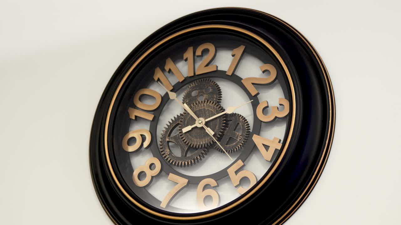 Vintage design wooden wall clock with open mechanism shows ten to two, white background