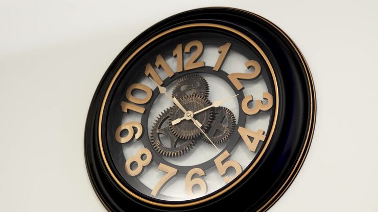 Vintage design wooden wall clock with open mechanism shows ten to two, white background