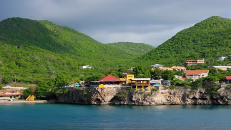 Vibrantes-Y-Coloridas-Casas-Sobre-Playa-Forti-Westpunt-Curacao,-Aérea