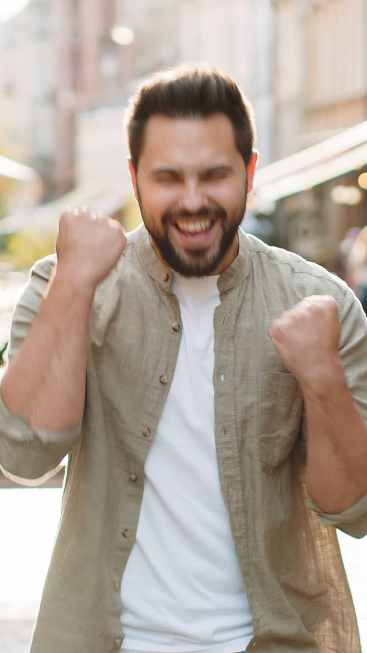 Giovane che grida, che celebra il successo, che vince, che raggiunge l'obiettivo, che porta buone notizie di vittoria per le strade della città.
