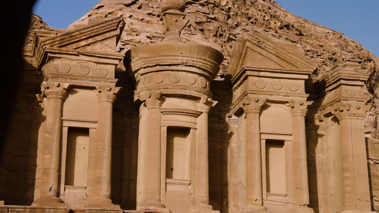 revela un edificio monumental tallado en la roca en el monasterio de ad deir en petra, jordania durante la puesta del sol