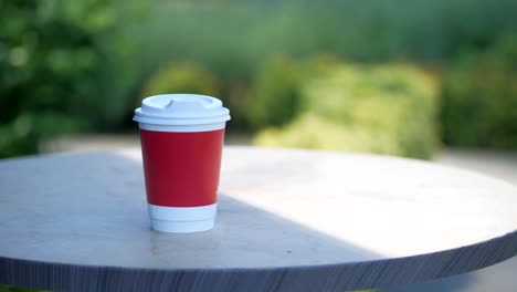 red coffee cup on outdoor table