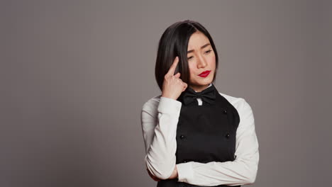 restaurant hostess being thoughtful over grey background