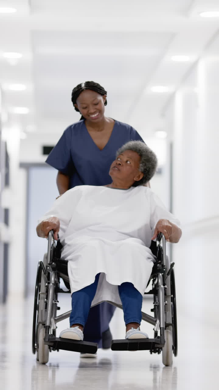 Vertical video of senior african american woman and female doctor, slow motion, copy space