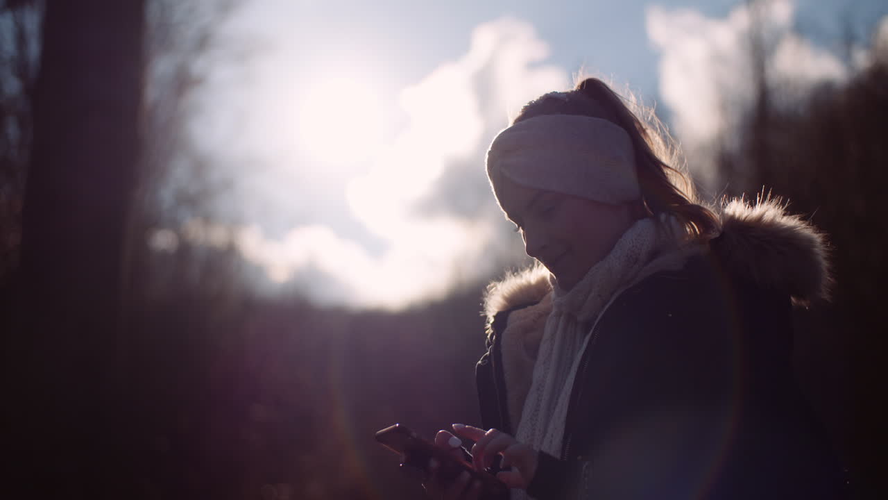 가을에 사진을 찍기 위해 스마트폰을 사용하는 기술 여성 4