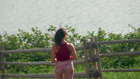 A-young-woman-takes-a-photo-of-an-ocean-view-with-a-smartphone