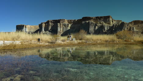 Transparent-Water-With-Men-Walking-Near-Blue-Lake-In-Band-e-Amir-National-Park-In-Bamyan,-Province-Of-Central-Afghanistan