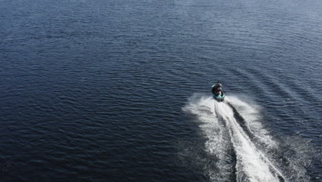 Luftaufnahme-Eines-Jungen-Mannes,-Der-Auf-Einem-Jetski-Sehr-Schnell-Auf-Dem-Wasser-In-Schweden-Fährt