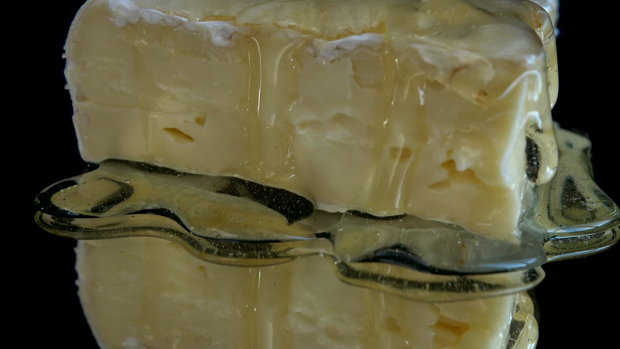 거울 같은 검은 바탕에 브리 치즈에서 흘러내리는 방울.