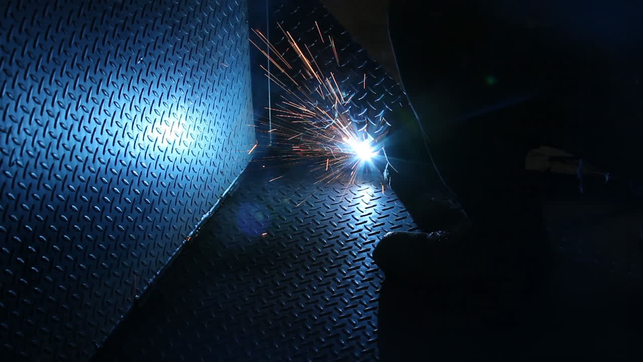 Blinding welding arc smoldering metal sheet so that it's connected
