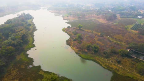 aerial: river flowing through bangladesh countryside farming land