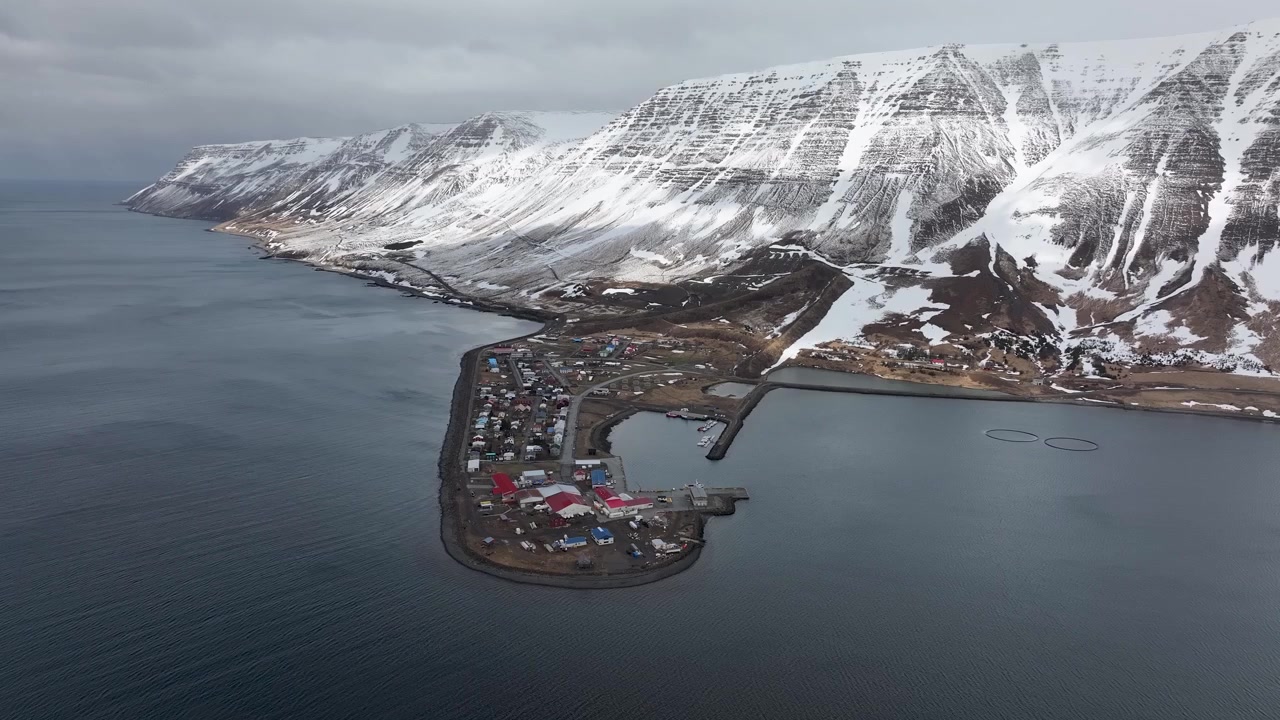 Et luftfoto med drone av den lille islandske landsbygda Flateyri i Vestfjordene på Island, under en rolig vinterdag i ildens og isens land