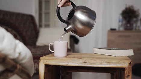 pouring hot tea kettle rusctic wood table