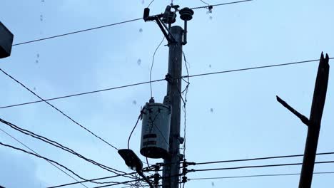 close-up of electrical pole and tangled wires under rainfall—perfect for infrastructure, weather, or gritty urban b-roll