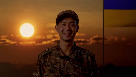 soldado sonriente en uniforme de camuflaje al atardecer con bandera ucraniana