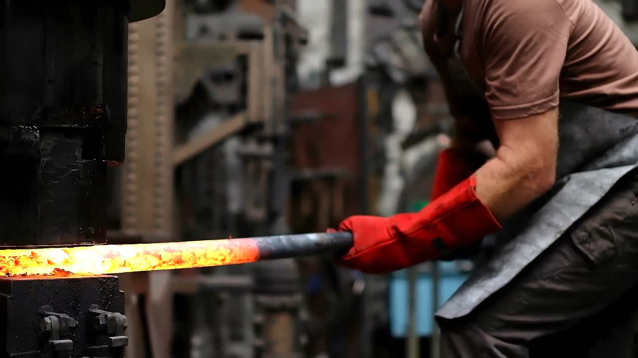 Fabbro che forgia il metallo fuso con il maglio 4k