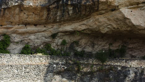 woman walking her dog along the dramatic mirador al puente romano. aerial tracking shot.