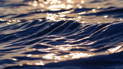 Close-up video shot of shimmering ocean waves at sunset, capturing the serene beauty and reflective