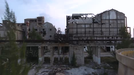 rust and decay on ruins of abandoned oil refinery, aerial dolly shot