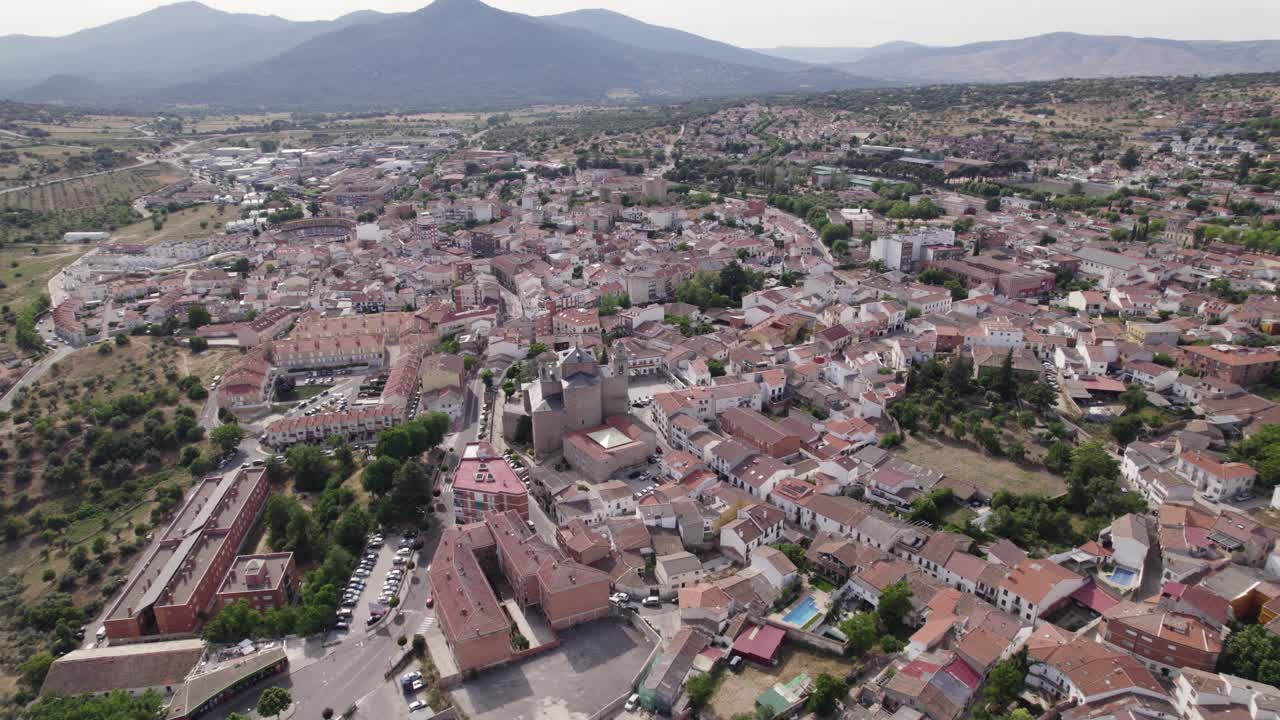Veduta aerea di apertura che si alza sopra le idilliache vie della tradizionale cittadina spagnola di San Martín de Valdeiglesias e il paesaggio montano.