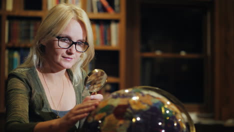 una mujer mira un hermoso globo en la biblioteca