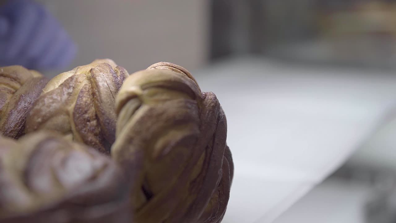 Worker's Hand In Gloves Putting Freshly Baked Pastries In The Shelf At The Cafeteria