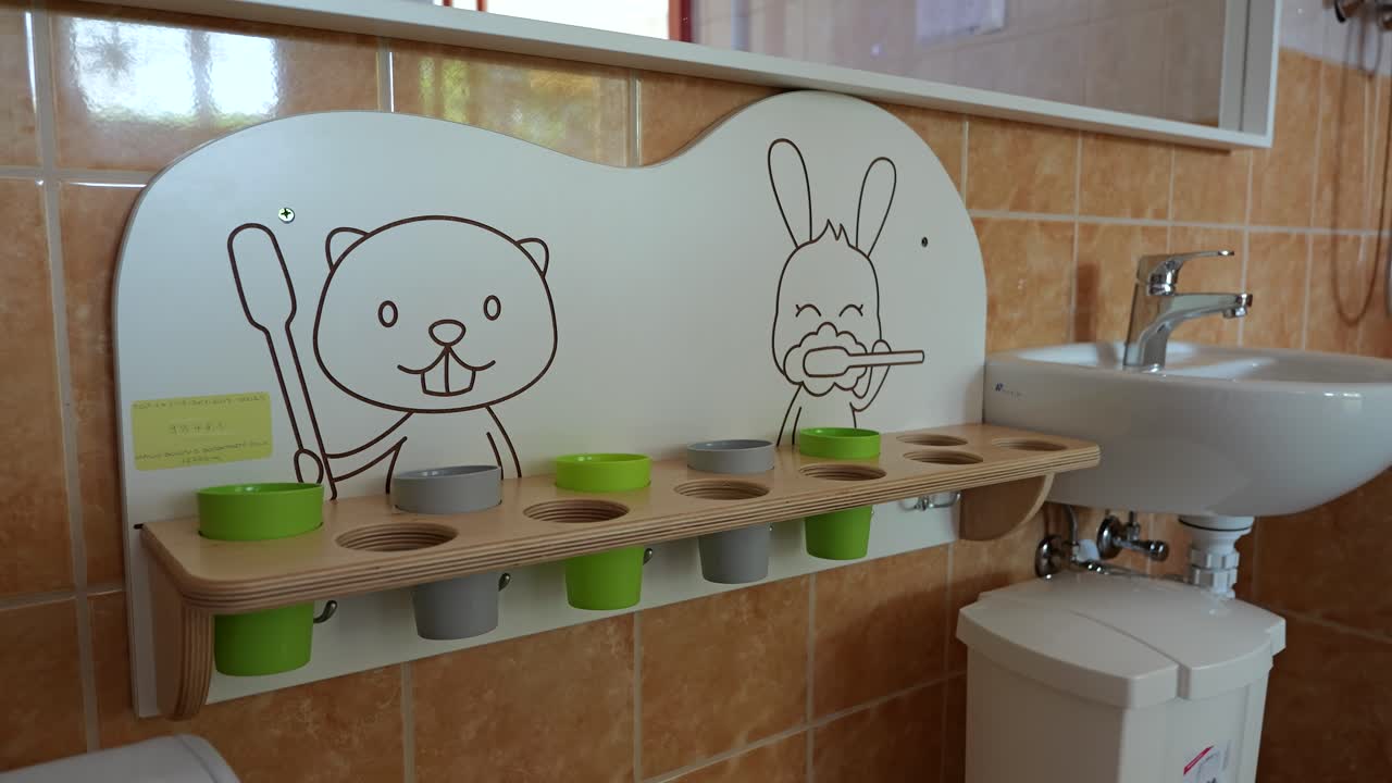 Sink, cute rack for toothbrushes in kindergarten classroom